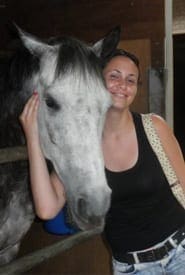 לירון דוידוביץ' - סטודנטית ללימודי וטרינריה בחו"ל מלטפת סוס בפקולטה לוטרינריה
